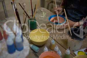 Mid section of girl painting a bowl