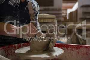 Male potter making a pot in pottery workshop