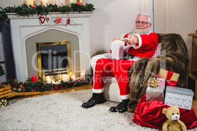 Santa Claus holding television remote control