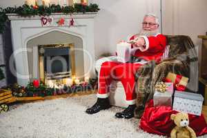 Santa Claus holding television remote control