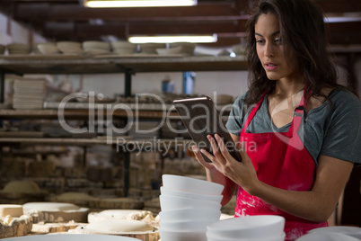 Female potter using digital tablet