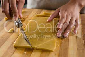 Woman slicing dough on chopping board