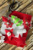 Handmade christmas trees and craft material on wooden plank