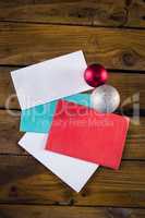 Envelopes and christmas baubles on wooden table