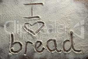 The word I love bread written on sprinkled flour