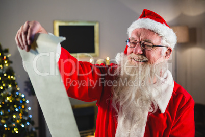 Santa Claus reading scroll in living room