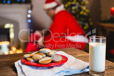 Cookies in plate with a glass of milk on table