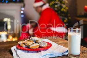 Cookies in plate with a glass of milk on table
