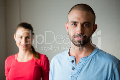 Portrait of yoga instructor with student standing in studio