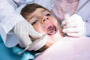 Dentist examining boy mouth at medical clinic