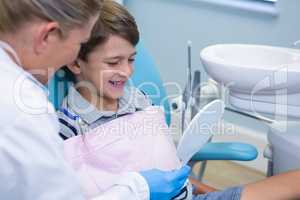 Dentist showing mirrior to boy