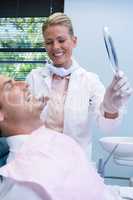 Dentist showing mirrior to patient