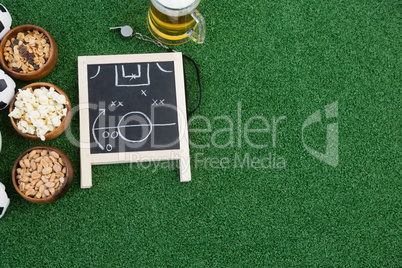 Strategy board, whistle and snacks on artificial grass