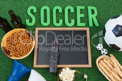 Chalkboard, snacks and football on artificial grass