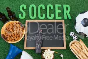 Chalkboard, snacks and football on artificial grass
