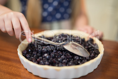 Young girl preparing blue berry pie