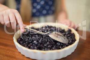 Young girl preparing blue berry pie