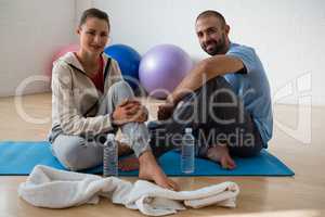 Portrait of student with instructor relaxing in yoga studio