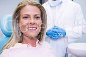 Portrait of patient sitting on chair against dentist