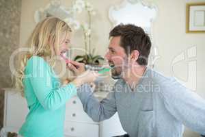 Father and daughter brushing each others teeth