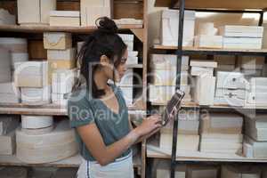 Female potter using digital tablet