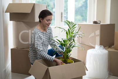 Woman opening cardboard boxes in living room