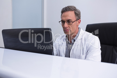 Dentist sitting by computer at table