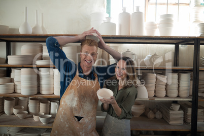 Portrait of male and female potter holding bowl