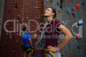 Athlete with rope looking up while men interacting in background