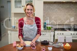Smiling woman preparing pan cake in kitchen