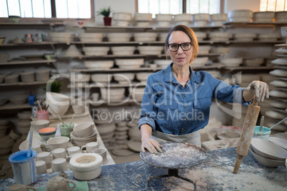 Female potter standing at worktop