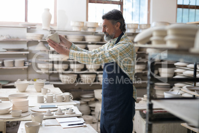 Male potter checking craft product