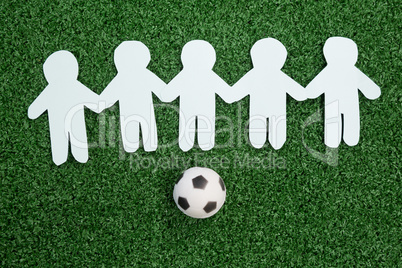 Paper cut outs and footballs arranged on artificial grass