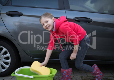 Teenage girl washing a car on a sunny day