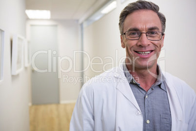 Portrait of smiling dentist standing at lobby