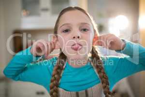 Young girl making funny faces at home
