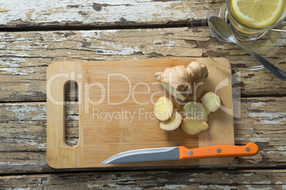 Overhead view of gingers on cutting board by tea over weathered table