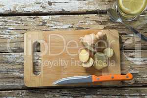 Overhead view of gingers on cutting board by tea over weathered table