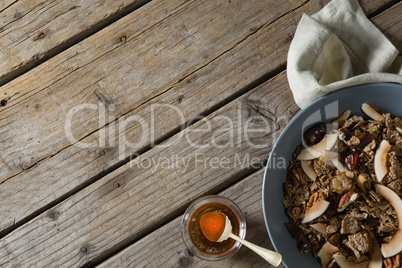 Healthy breakfast in bowl and honey on a wooden table