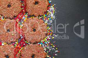 Chocolate biscuits rings with Christmas decoration on black slat