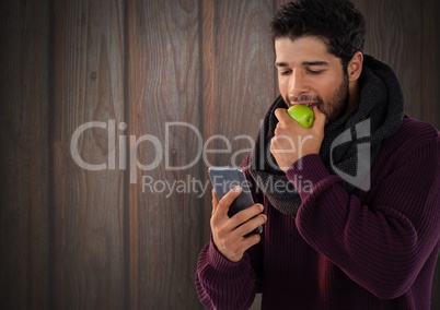 Man against wood with apple and phone