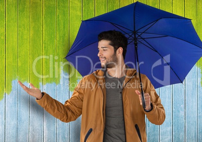 Man against wood with umbrella and coat