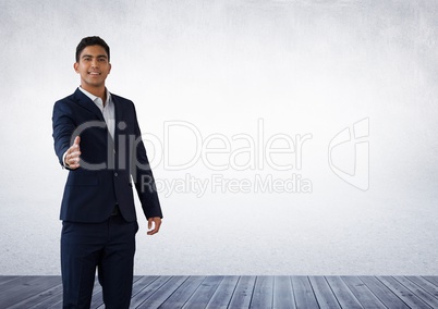 Businessman reaching for handshake in room