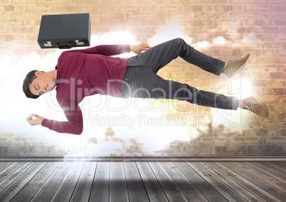 Businessman with briefcase floating magically over cloudy wall with illuminated light bursts