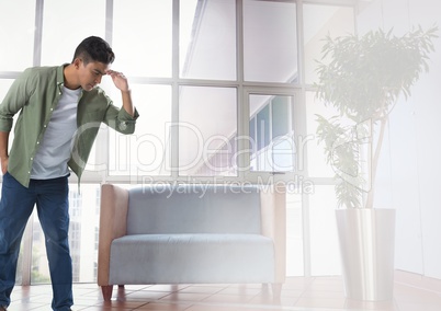 Businessman looking down with chair in waiting room