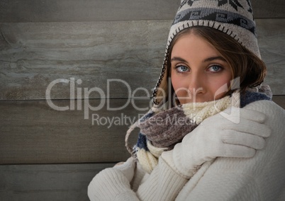 Woman against wood with warm hat and scarf and gloves