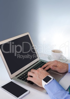 Businessman with laptop and phone at desk with bright background