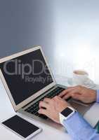 Businessman with laptop and phone at desk with bright background