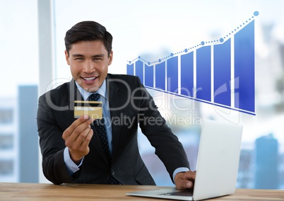 Businessman at desk with laptop and bank card and bar chart incrementing