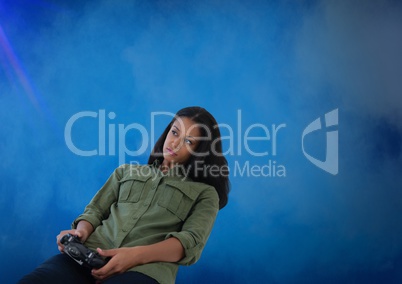 Businesswoman playing with computer game controller with blue fog background